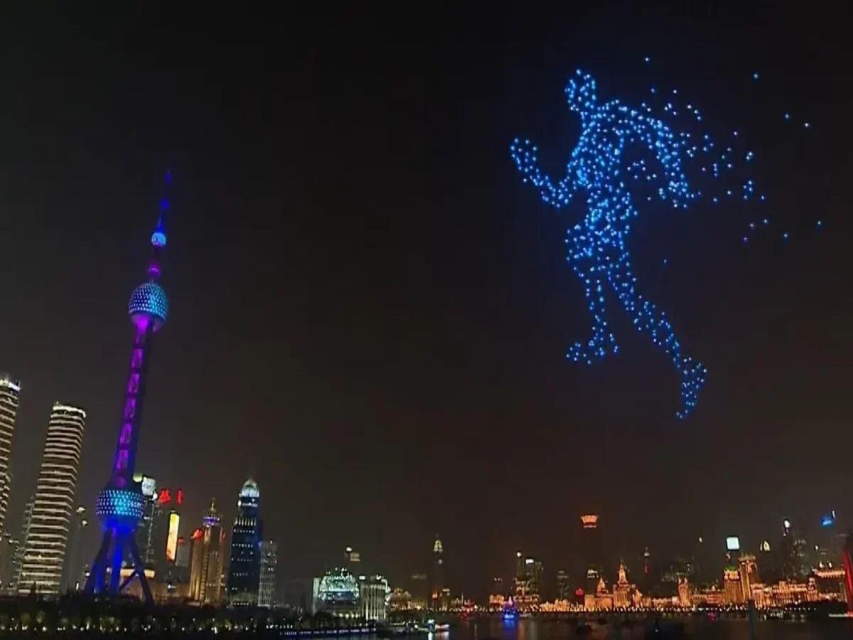 Crostars drone light show night performance, Shanghai skyline with Oriental Pearl Tower, human figure formation in blue lights