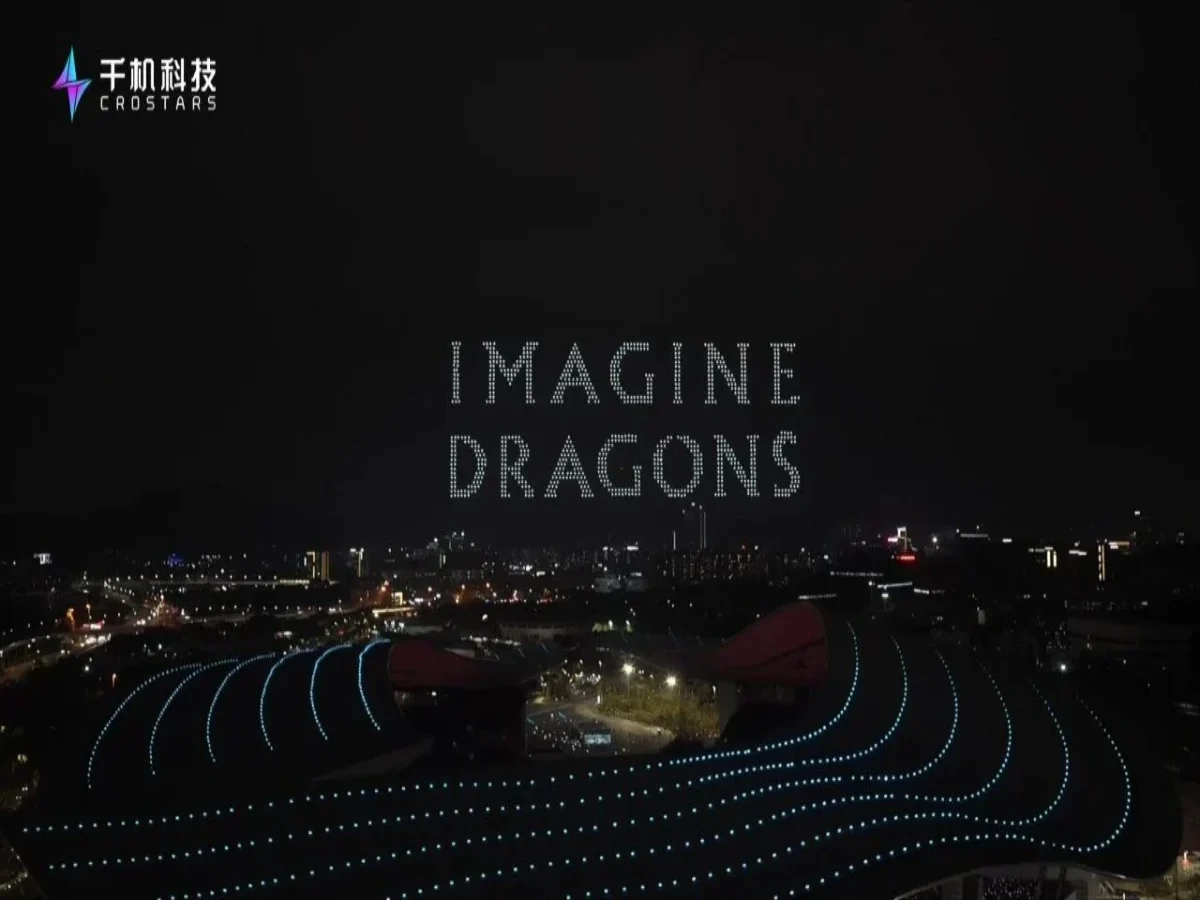 Crostars drones forming IMAGINE DRAGONS text above Guangdong Olympic Sports Center Stadium at night, Guangzhou March 2026 — blue wave pattern formations visible around the venue] [PHOTO 2 — ALT: Crostars drone light show night performance, Guangdong Olympic Sports Center, Guangzhou, March 2026 — Dan Reynolds of Imagine Dragons performing on stage with drone formation visible in background] [PHOTO 3 — ALT: Crostars drones forming a Chinese dragon above Guangdong Olympic Sports Center Stadium at night, Guangzhou, March 2026