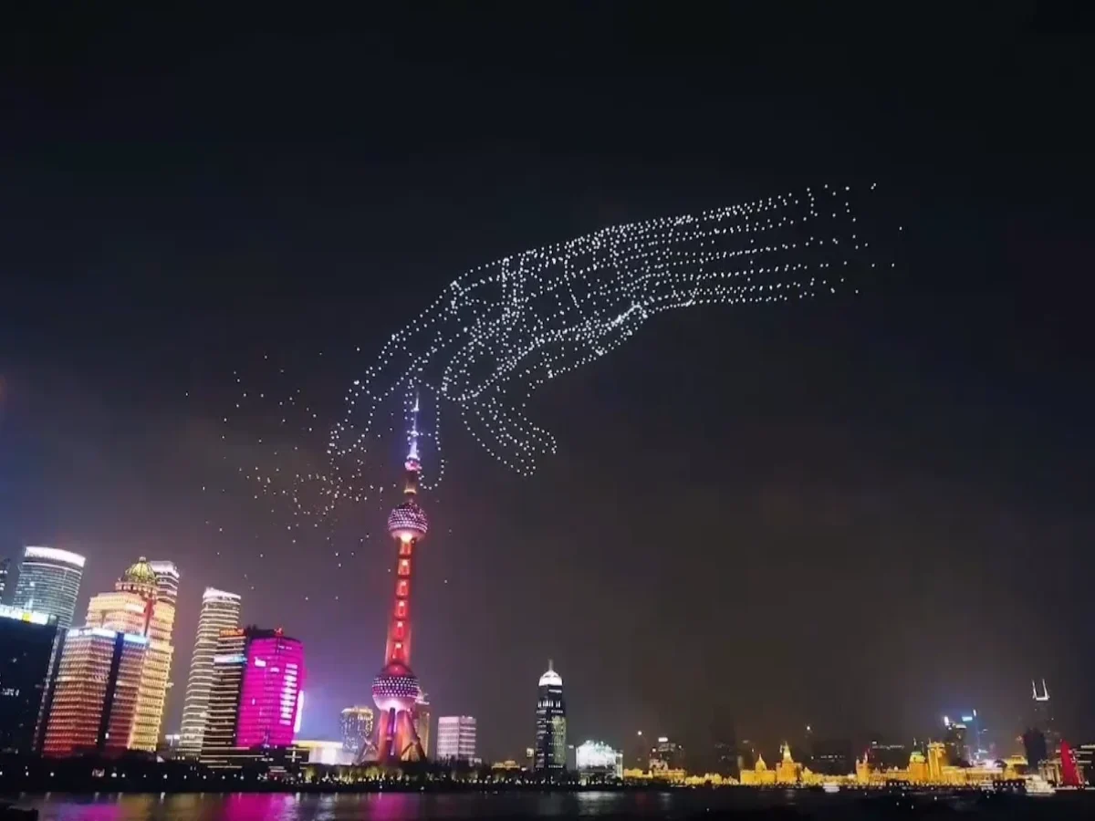 Crostars drone light show night performance, Shanghai Bund with Oriental Pearl Tower, large human hand formation in white lights