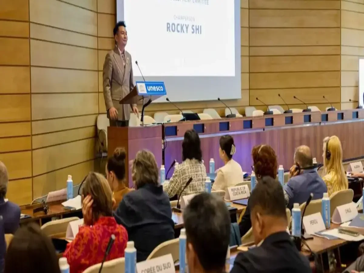 Shi Zheyuan (Rocky Shi) speaking at UNESCO headquarters podium, Paris July 2025 — screen shows World Low-Altitude Economy and Art Development Committee Chairperson Rocky Shi — country name plates including Costa Rica, Peru, Chile, South Korea visible