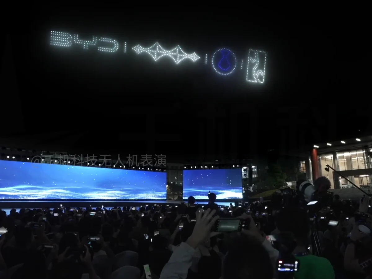 Crostars 1,000 drones forming BYD logo above Shenzhen technology conference stage with live audience