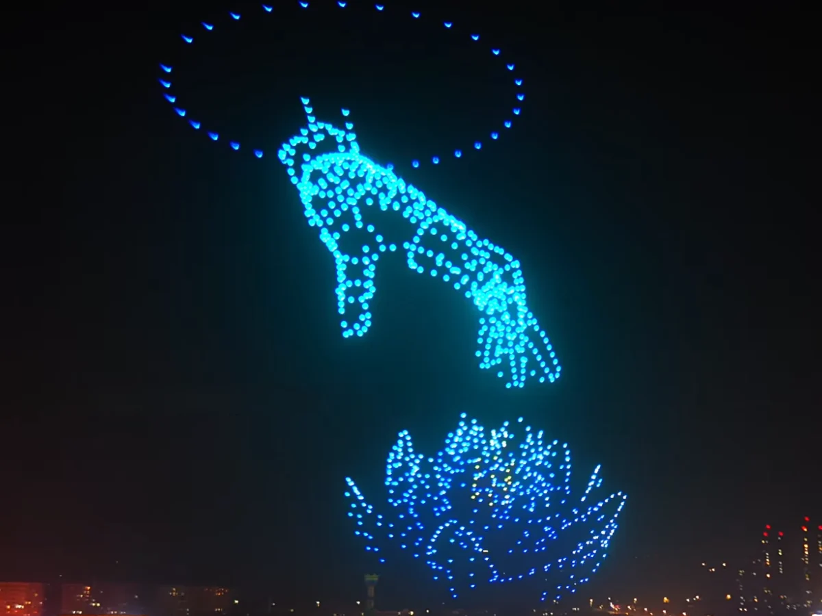 Crostars drones forming divine hand releasing lotus flower above Luohe city skyline, 2026